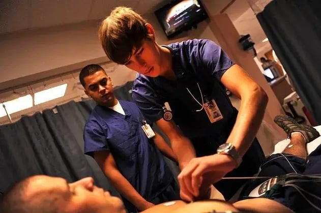 US_Navy_110727-N-YR391-008_Hospitalman_Edwin_Torres_instructs_Jurgen_Comberg_2C_a_college_preparatory_medical_arts_magnet_high_school_student_attendi